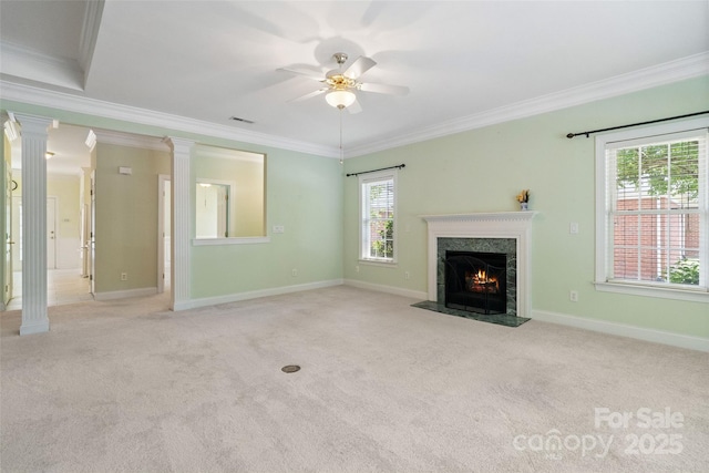 unfurnished living room with a ceiling fan, ornate columns, a fireplace, carpet floors, and ornamental molding