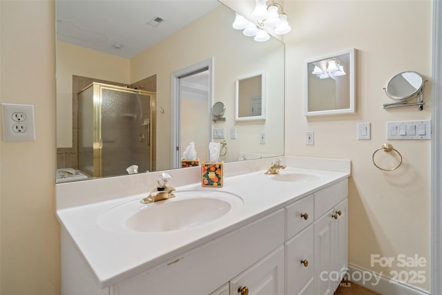 full bathroom featuring double vanity, visible vents, a stall shower, and a sink