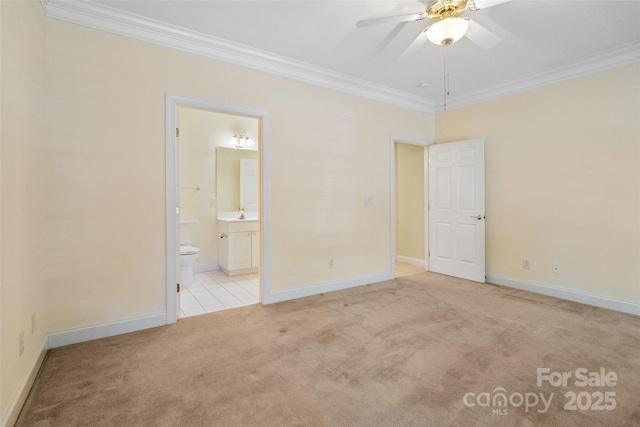 unfurnished bedroom with ensuite bathroom, ornamental molding, carpet floors, and baseboards