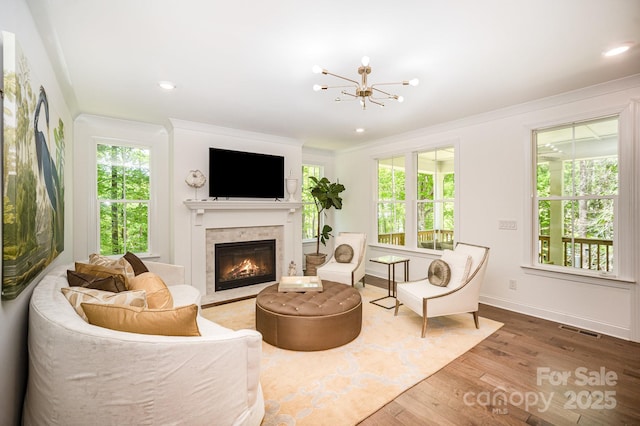16432 Here At Last Ln, Charlotte, NC 28278 - living area with visible vents, wood finished floors, a chandelier, a glass covered fireplace, and ornamental molding