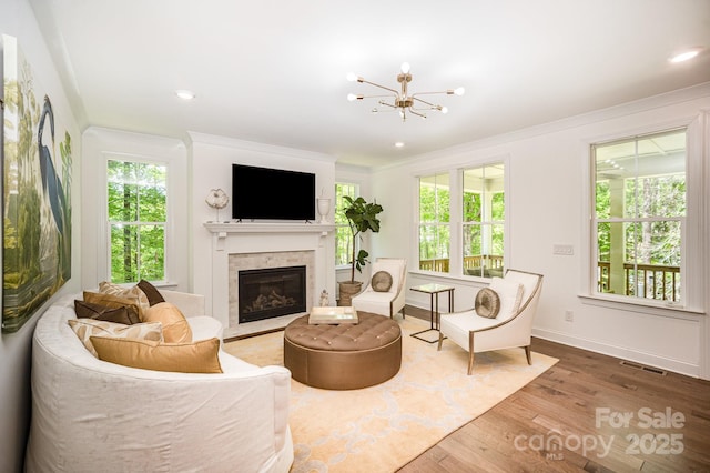 16432 Here At Last Ln, Charlotte, NC 28278 - living room featuring a notable chandelier, a glass covered fireplace, wood finished floors, visible vents, and ornamental molding