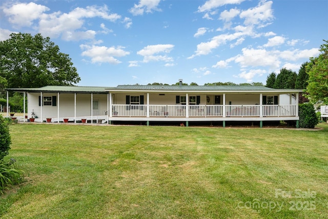 rear view of house featuring metal roof and a lawn