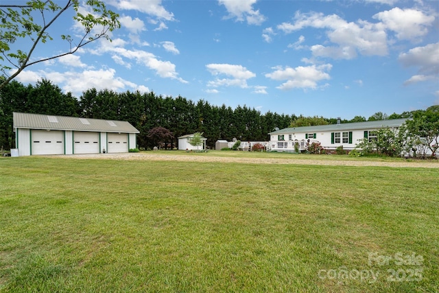 view of yard featuring an outdoor structure and a detached garage