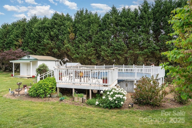 exterior space featuring a yard, an outdoor structure, a wooden deck, and a shed