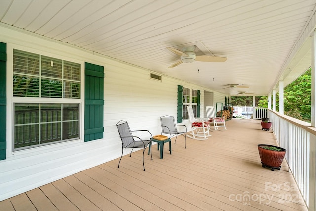wooden deck with a porch, visible vents, and a ceiling fan