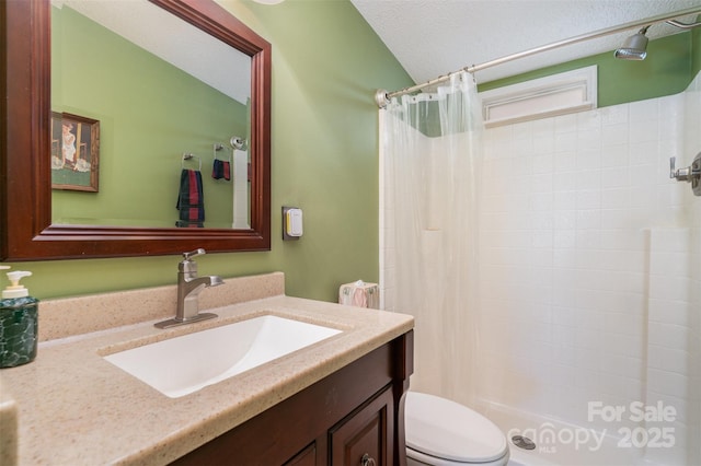 full bath with toilet, vanity, a tile shower, and a textured ceiling