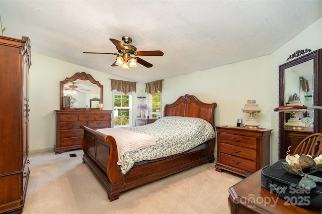 bedroom with light colored carpet, a textured ceiling, and a ceiling fan