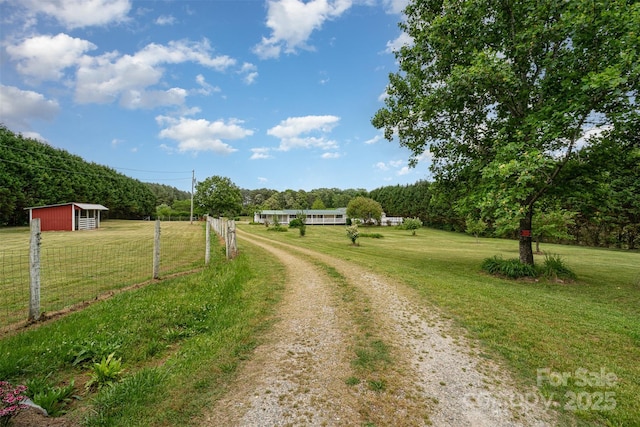 view of street with a rural view and driveway