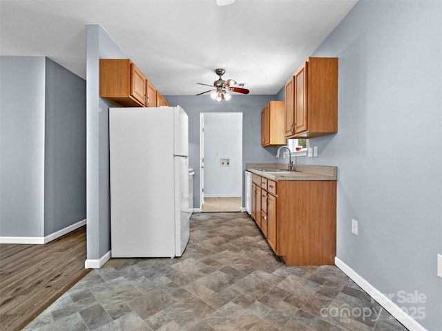 66 Avondale Heights Rd, Asheville, NC 28803 - kitchen with freestanding refrigerator, ceiling fan, stone finish floors, light countertops, and brown cabinets