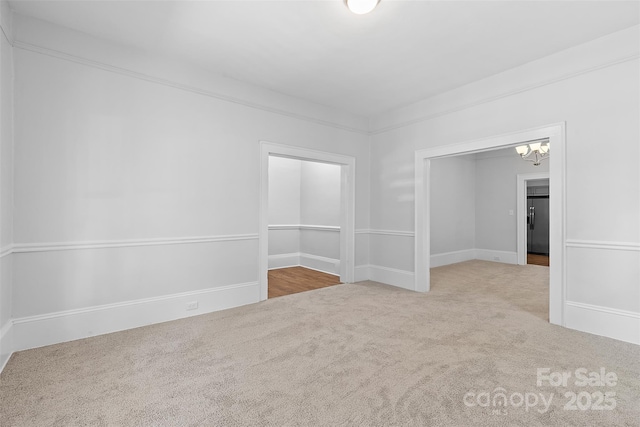 carpeted empty room with a chandelier