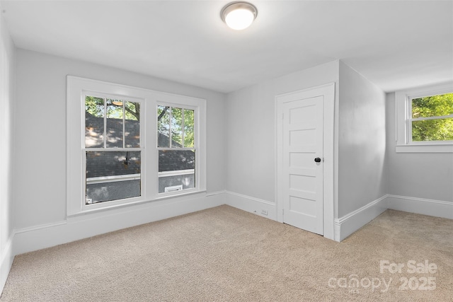 empty room featuring baseboards and carpet flooring
