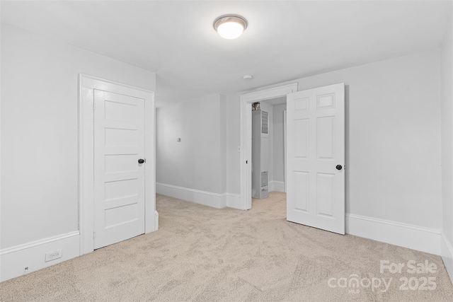 unfurnished bedroom featuring carpet flooring and baseboards