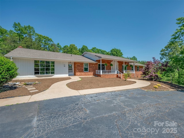 ranch-style house with a porch and brick siding