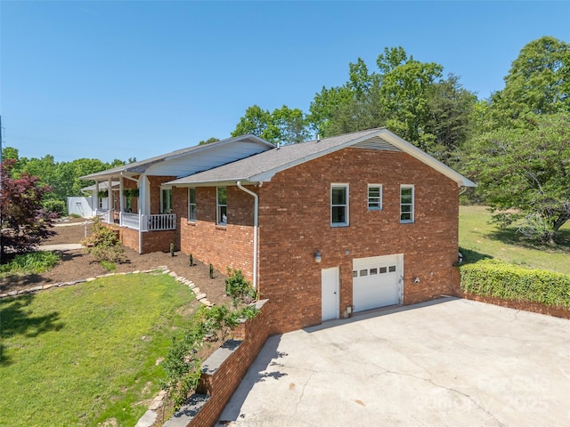 view of property exterior featuring a porch, a yard, a garage, brick siding, and concrete driveway
