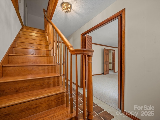 stairs featuring tile patterned flooring, carpet flooring, and baseboards