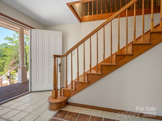 entrance foyer with plenty of natural light, tile patterned flooring, and stairway