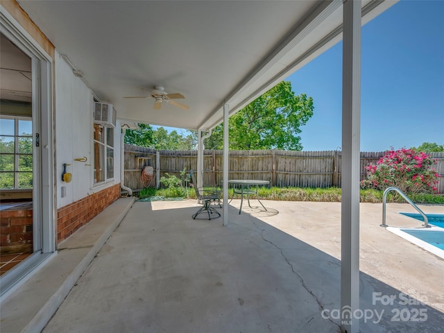 view of patio featuring a fenced backyard, a fenced in pool, ceiling fan, and an AC wall unit