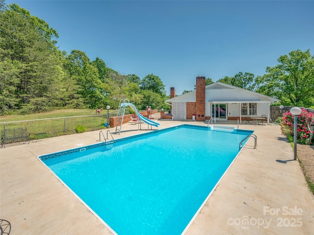 view of pool featuring a fenced in pool, a patio area, a water slide, and fence