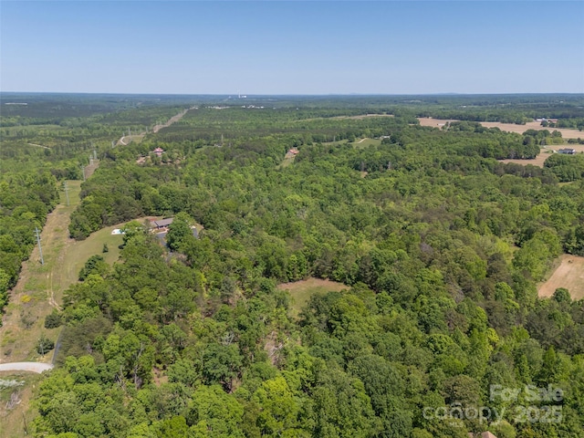 birds eye view of property featuring a view of trees