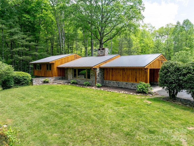 100 Ashton Ln, Brevard, NC 28712 - view of front facade with a front yard, stone siding, a chimney, metal roof, and board and batten siding