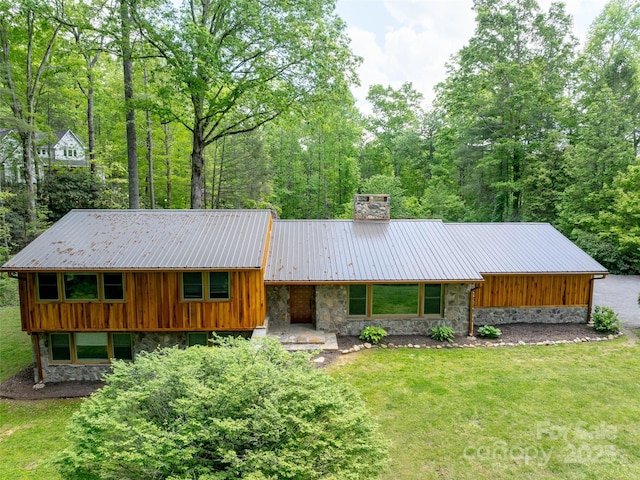 100 Ashton Ln, Brevard, NC 28712 - view of front of home featuring stone siding, a chimney, a front yard, and metal roof