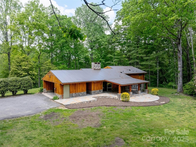 100 Ashton Ln, Brevard, NC 28712 - rear view of house featuring a chimney, a yard, asphalt driveway, stone siding, and board and batten siding