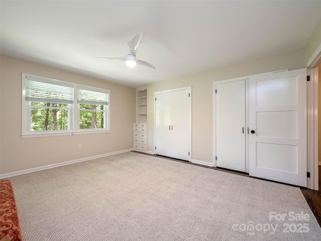 100 Ashton Ln, Brevard, NC 28712 - unfurnished bedroom featuring two closets, baseboards, ceiling fan, and carpet flooring