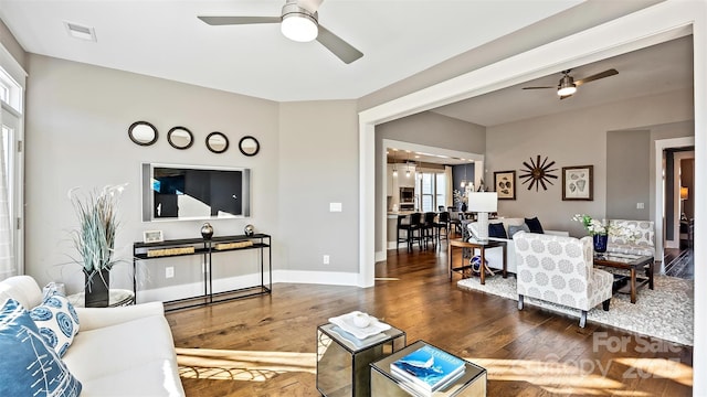 living area featuring wood-type flooring, ceiling fan, visible vents, and a healthy amount of sunlight