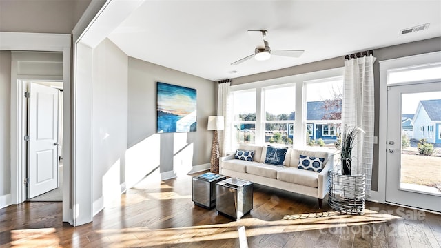 living area featuring baseboards, visible vents, a wealth of natural light, and wood finished floors