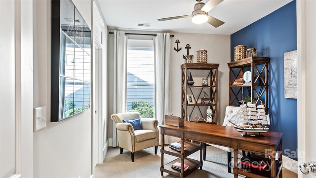 home office with a healthy amount of sunlight, ceiling fan, light colored carpet, and visible vents