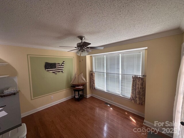 spare room with crown molding, a ceiling fan, a textured ceiling, and wood finished floors