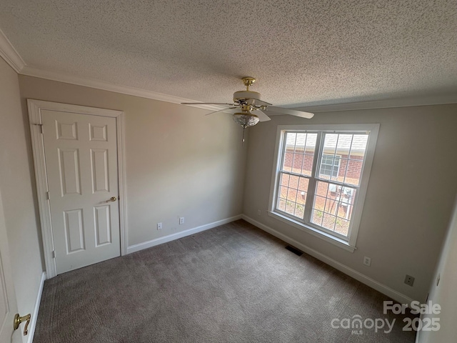 carpeted spare room featuring crown molding, a textured ceiling, a ceiling fan, baseboards, and visible vents