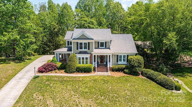 traditional-style house featuring a chimney and a front yard