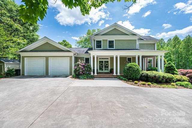 neoclassical / greek revival house with a garage, concrete driveway, and a porch