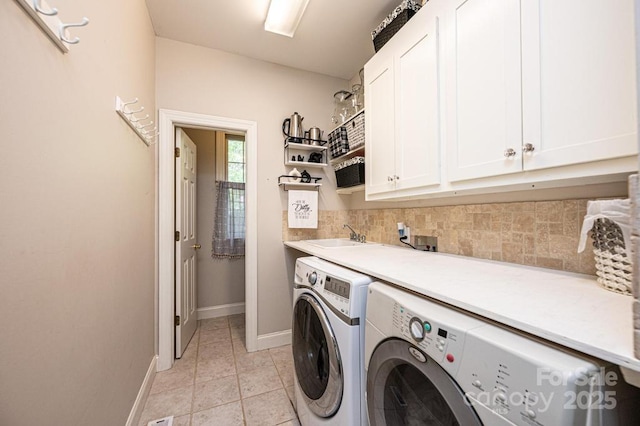 washroom featuring cabinet space, independent washer and dryer, baseboards, and light tile patterned floors