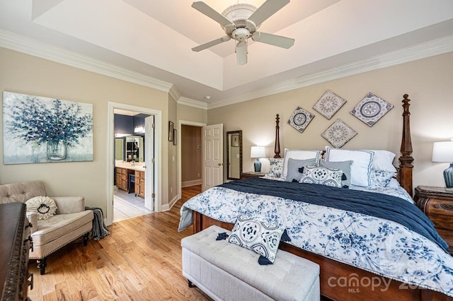 bedroom with ceiling fan, crown molding, light wood-type flooring, a raised ceiling, and baseboards
