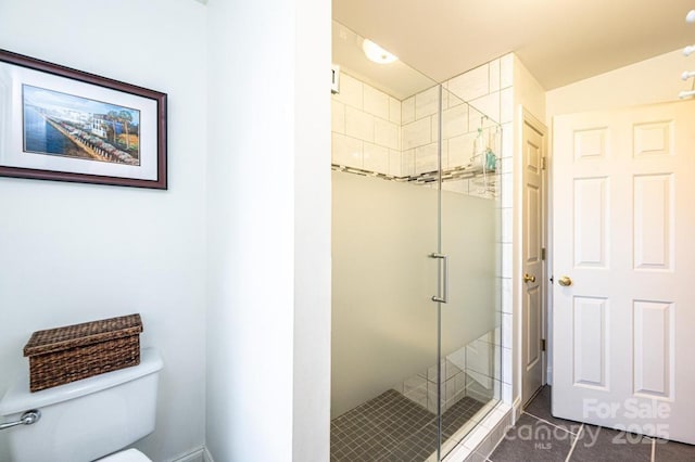 full bath featuring toilet, tile patterned flooring, and a stall shower