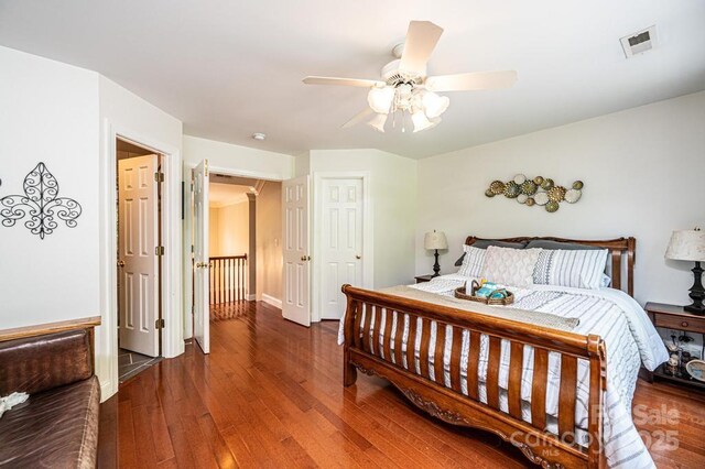 bedroom featuring a ceiling fan, baseboards, visible vents, and hardwood / wood-style floors