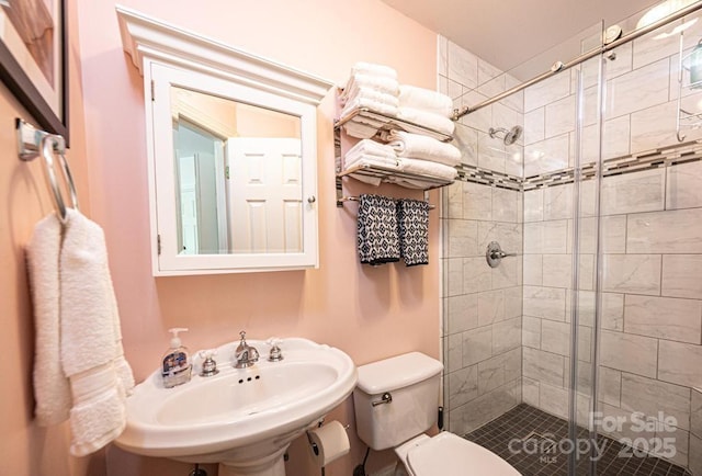 full bath with a sink, a stall shower, and toilet