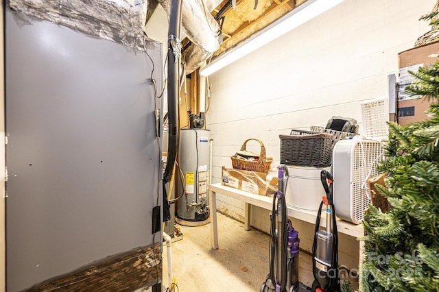 unfinished below grade area featuring water heater and concrete block wall