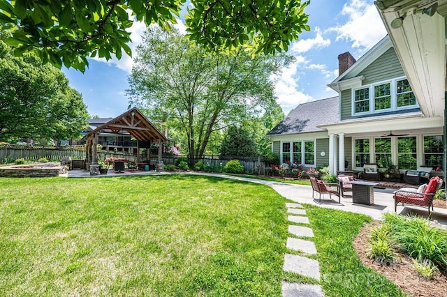 view of yard with a gazebo, a fenced backyard, an outdoor living space, a patio area, and a ceiling fan