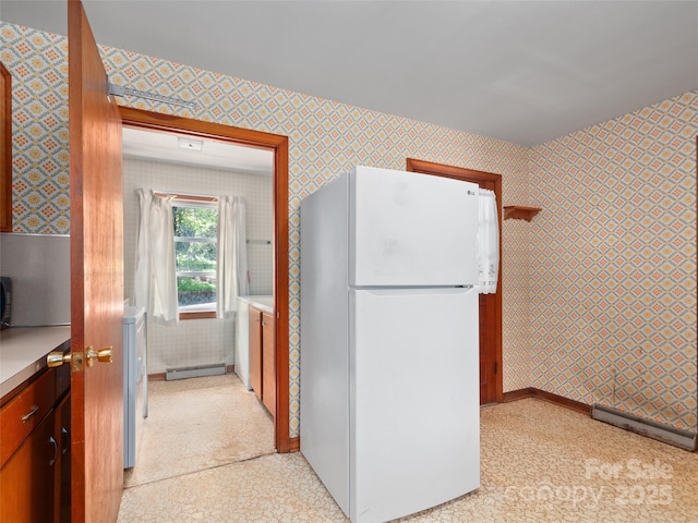 kitchen with light floors, baseboards, freestanding refrigerator, and wallpapered walls