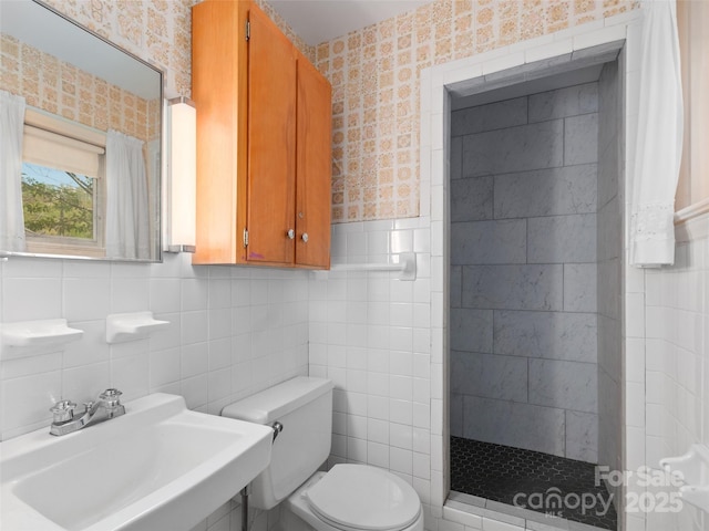 full bath featuring a sink, tile walls, a tile shower, and toilet