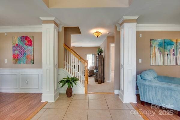 136 Elba Dr, Mooresville, NC 28115 - entrance foyer with decorative columns, stairs, light wood-type flooring, ornamental molding, and a wainscoted wall