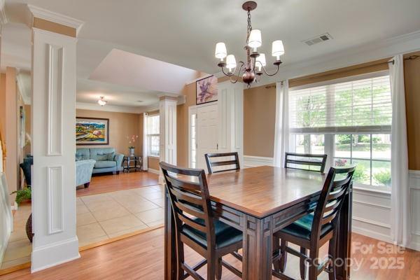 136 Elba Dr, Mooresville, NC 28115 - dining area featuring decorative columns, a chandelier, healthy amount of natural light, and ornamental molding