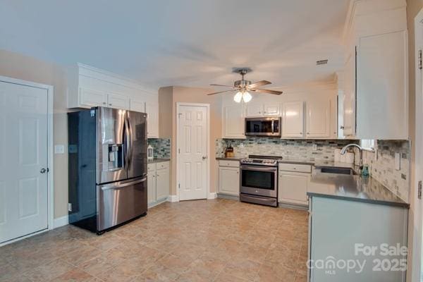 136 Elba Dr, Mooresville, NC 28115 - kitchen with stainless steel appliances, ceiling fan, tasteful backsplash, and white cabinetry