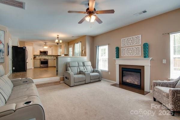 136 Elba Dr, Mooresville, NC 28115 - living area featuring ceiling fan, a fireplace with flush hearth, and light carpet