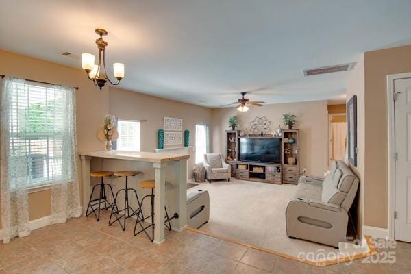 136 Elba Dr, Mooresville, NC 28115 - carpeted living room with plenty of natural light, a ceiling fan, a chandelier, and tile patterned floors