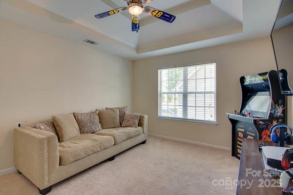 136 Elba Dr, Mooresville, NC 28115 - carpeted living area with a ceiling fan and a tray ceiling