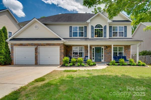 136 Elba Dr, Mooresville, NC 28115 - view of front of house with concrete driveway, covered porch, a garage, and stone siding